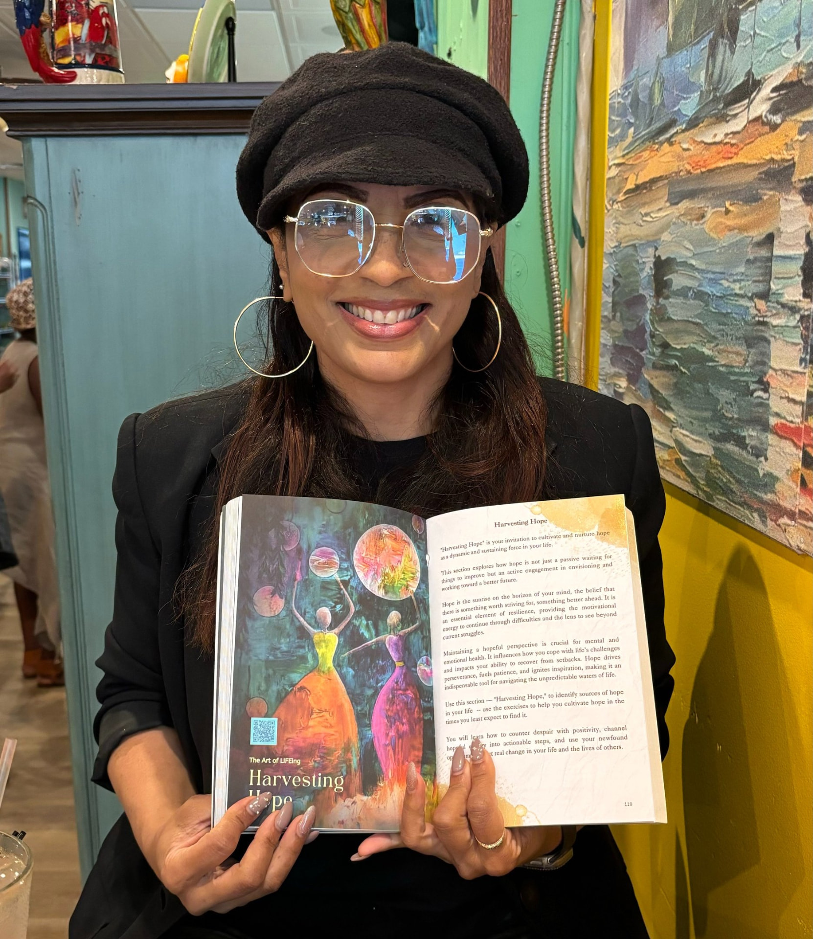 Reader holding The Art of LIFEing Journal open to the Harvesting Hope chapter