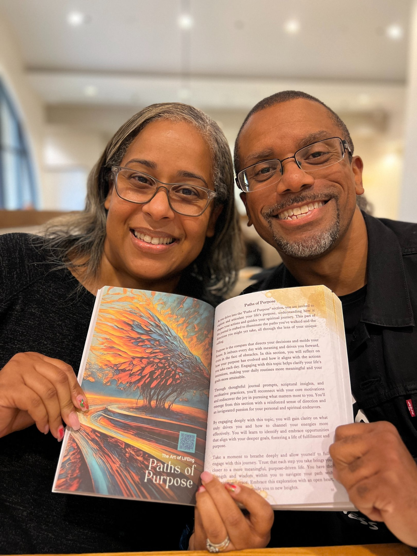 Two readers holding The Art of LIFEing Journal open to the Paths of Purpose chapter